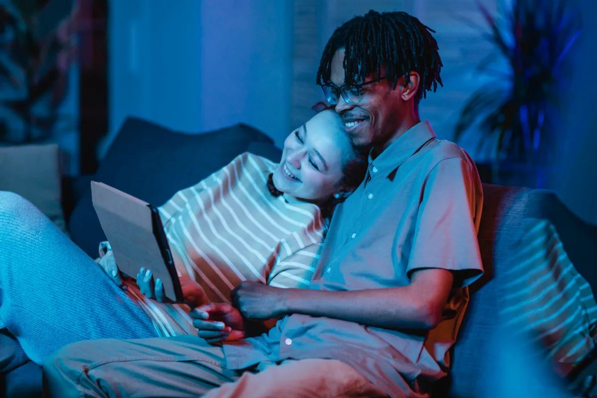 A couple at home on the sofa using fast wireless internet